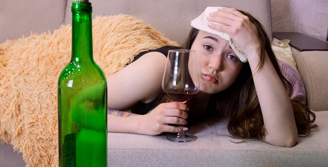девушка в кровати со стаканом алкоголя
