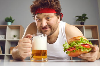 Мужчина смотрит на кружку пива в своей руке